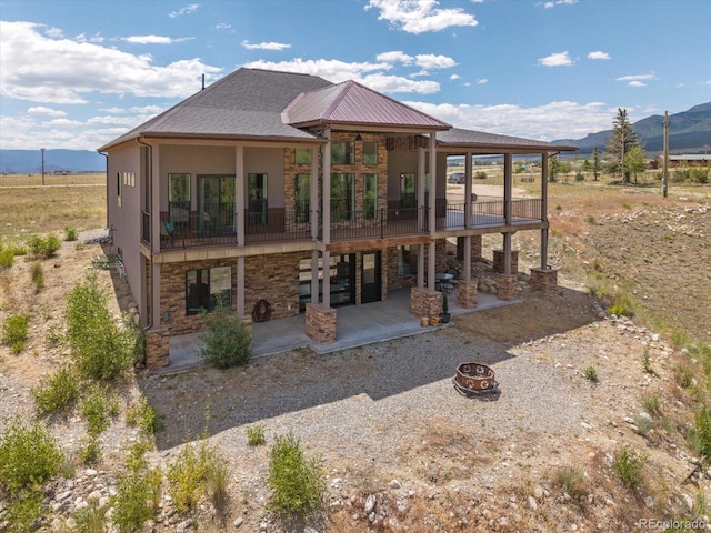 16985 County Road 306, Buena Vista, CO 81211 - back of house featuring a patio, a fire pit, stone siding, and a mountain view