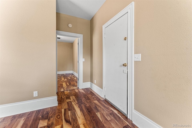 hall featuring baseboards and wood finished floors