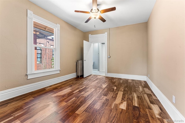 unfurnished room featuring a ceiling fan, baseboards, and wood finished floors