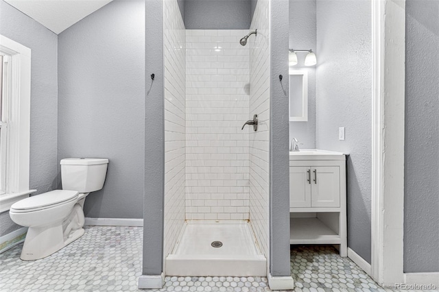 full bathroom featuring a stall shower, vanity, toilet, and baseboards