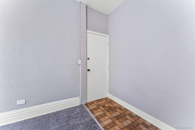 unfurnished room with baseboards