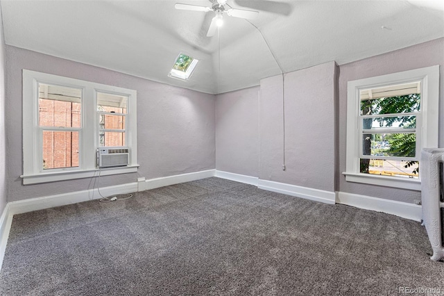 spare room featuring lofted ceiling, carpet flooring, ceiling fan, cooling unit, and baseboards