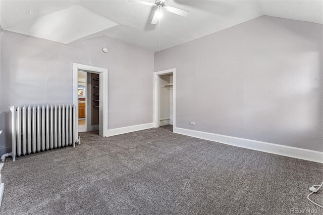 unfurnished bedroom with ceiling fan, carpet floors, baseboards, vaulted ceiling, and radiator