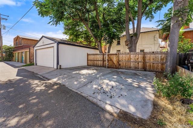 exterior space with a garage, brick siding, fence, and an outdoor structure