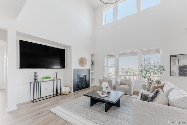 14345 Dahlia St, Thornton, CO 80602 - living area with a towering ceiling, built in features, wood finished floors, and a tile fireplace