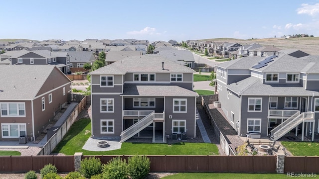 14345 Dahlia St, Thornton, CO 80602 - rear view of house featuring a fire pit, stairway, a fenced backyard, a residential view, and a patio