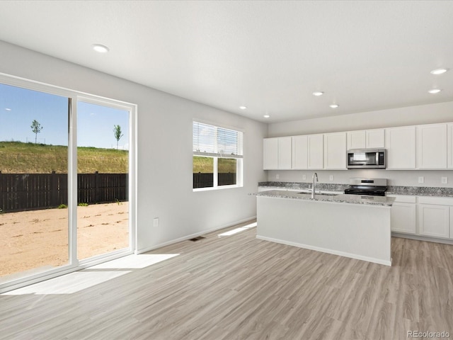 7324 27th Street Ln, Greeley, CO 80634 - kitchen featuring appliances with stainless steel finishes, a sink, recessed lighting, light wood finished floors, and white cabinets
