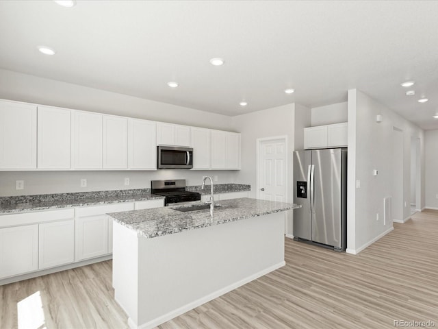 7324 27th Street Ln, Greeley, CO 80634 - kitchen with stainless steel appliances, a sink, light wood-type flooring, a kitchen island with sink, and recessed lighting