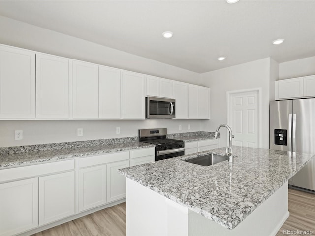 7324 27th Street Ln, Greeley, CO 80634 - kitchen featuring appliances with stainless steel finishes, a sink, light wood-style flooring, white cabinets, and recessed lighting