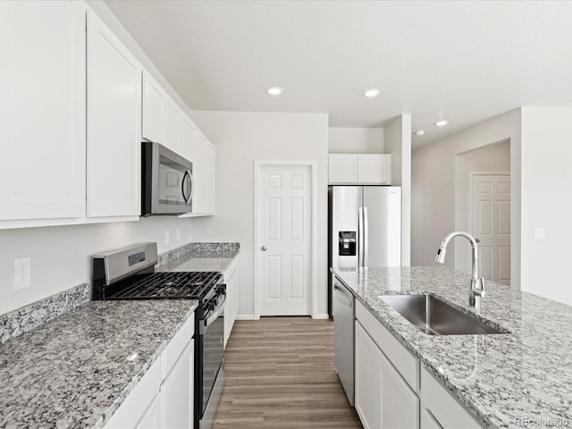 7324 27th Street Ln, Greeley, CO 80634 - kitchen with appliances with stainless steel finishes, a sink, light wood-type flooring, white cabinetry, and recessed lighting