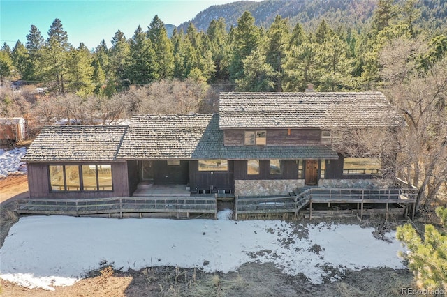 view of front of property featuring a forest view