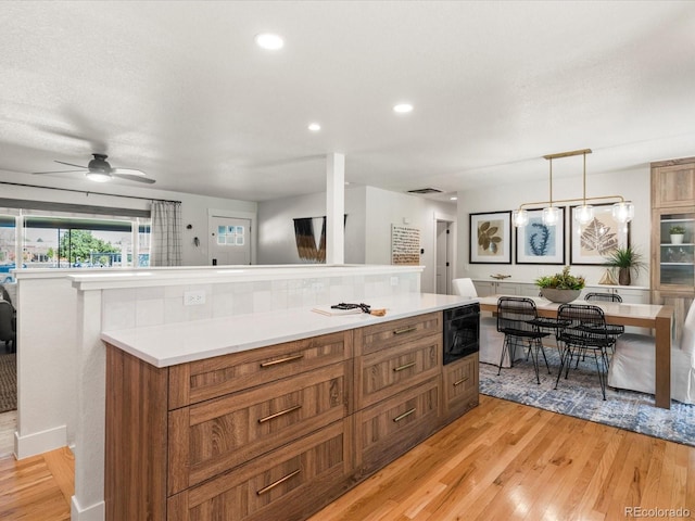 3560 S Glencoe St, Denver, CO 80237 - kitchen with light wood-style flooring, brown cabinetry, light countertops, ceiling fan, and recessed lighting