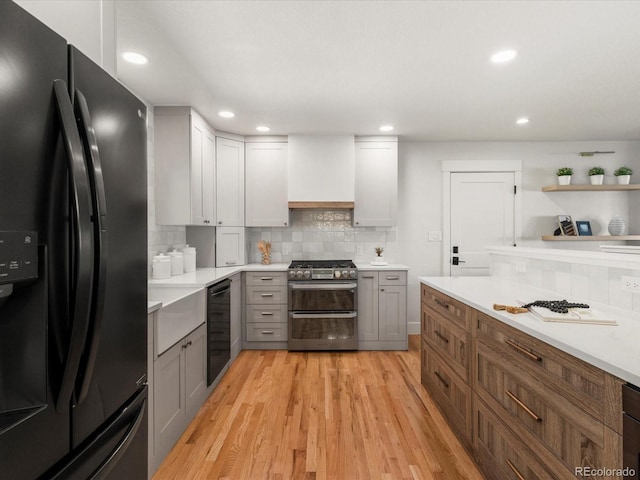 3560 S Glencoe St, Denver, CO 80237 - kitchen featuring black appliances, recessed lighting, tasteful backsplash, light wood-type flooring, and light countertops