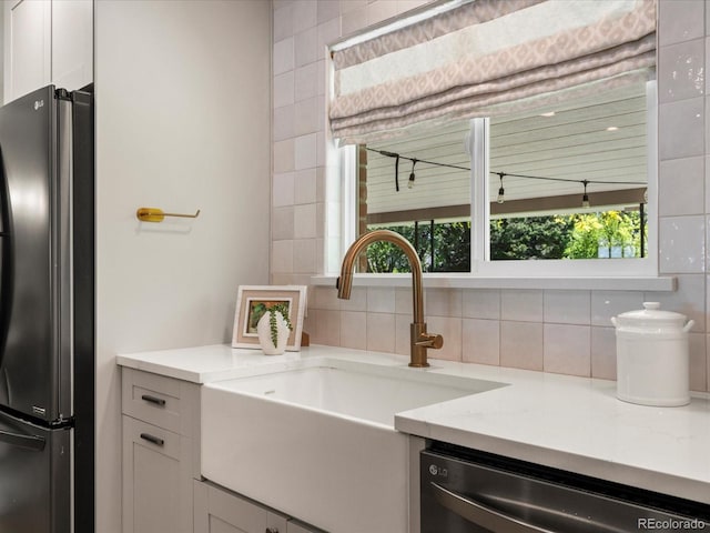 3560 S Glencoe St, Denver, CO 80237 - kitchen with freestanding refrigerator, a sink, stainless steel dishwasher, white cabinets, and backsplash