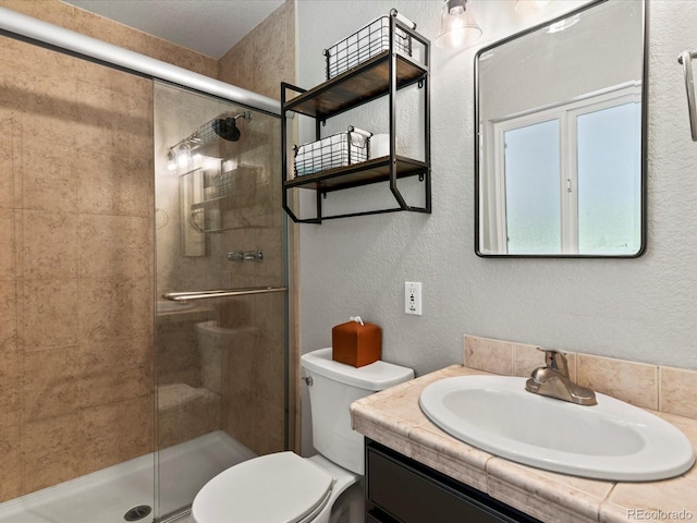3560 S Glencoe St, Denver, CO 80237 - bathroom with a stall shower, toilet, vanity, and a textured wall