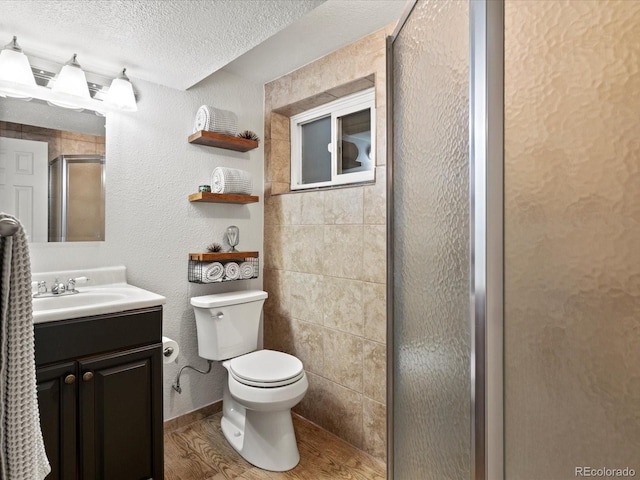 3560 S Glencoe St, Denver, CO 80237 - bathroom with a textured ceiling, a shower stall, vanity, wood finished floors, and a textured wall