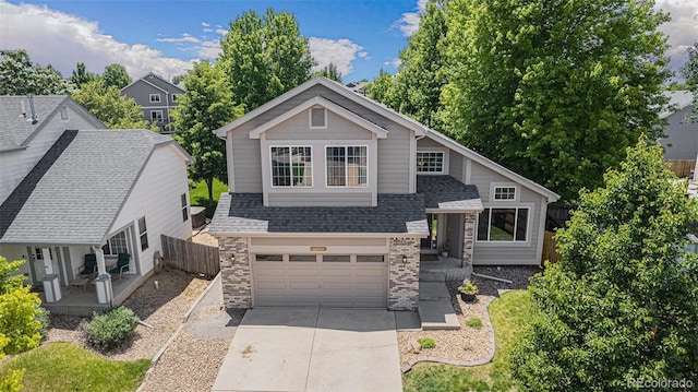 6230 Snowberry Ave, Firestone, CO 80504 - view of front of house with concrete driveway, a garage, a shingled roof, brick siding, and stone siding