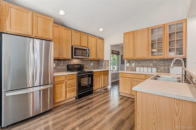 6230 Snowberry Ave, Firestone, CO 80504 - kitchen with appliances with stainless steel finishes, vaulted ceiling, light brown cabinetry, wood finished floors, and decorative backsplash
