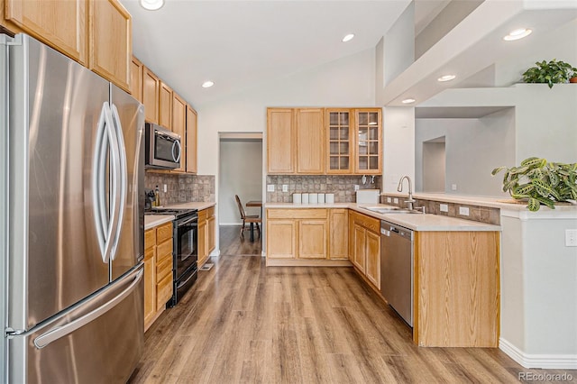6230 Snowberry Ave, Firestone, CO 80504 - kitchen with stainless steel appliances, light brown cabinets, a peninsula, light wood-type flooring, and vaulted ceiling