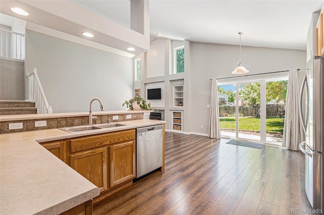6230 Snowberry Ave, Firestone, CO 80504 - kitchen featuring stainless steel appliances, brown cabinets, pendant lighting, dark wood-type flooring, and light countertops