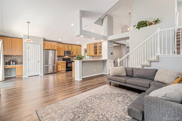 6230 Snowberry Ave, Firestone, CO 80504 - living room featuring wood finished floors, a high ceiling, stairway, and recessed lighting