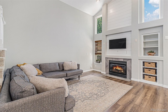 6230 Snowberry Ave, Firestone, CO 80504 - living room with a fireplace, wood finished floors, high vaulted ceiling, and built in shelves
