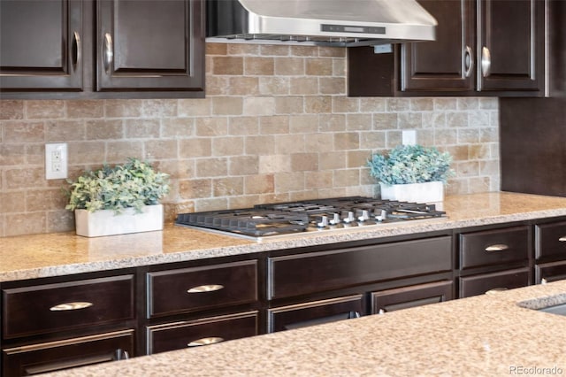 18180 W 84th Pl, Arvada, CO 80007 - kitchen with wall chimney exhaust hood, stainless steel gas stovetop, dark brown cabinetry, and backsplash