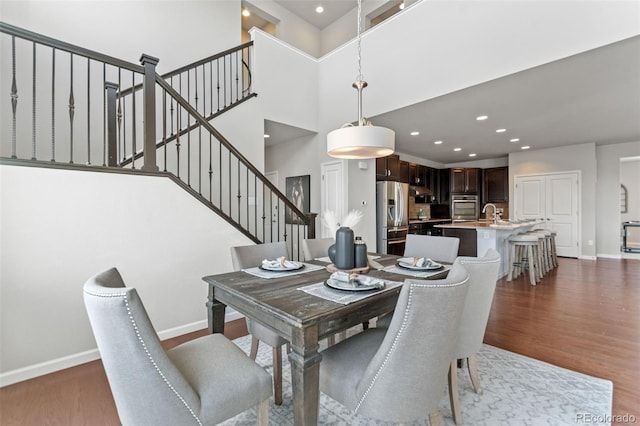 18180 W 84th Pl, Arvada, CO 80007 - dining space featuring dark wood-type flooring, stairs, a high ceiling, and recessed lighting