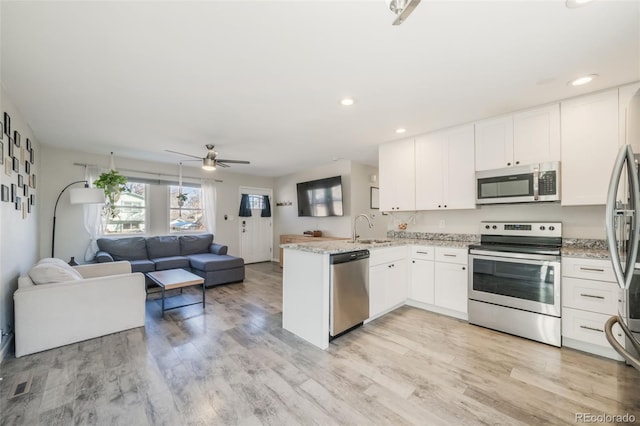 2240 Flintwood Dr, Colorado Springs, CO 80910 - kitchen with appliances with stainless steel finishes, open floor plan, a peninsula, white cabinetry, and a ceiling fan