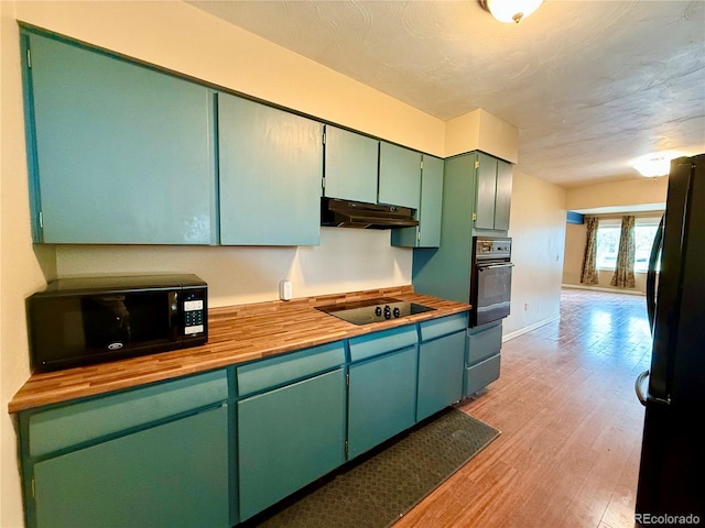 kitchen with black appliances, light wood-type flooring, and green cabinetry