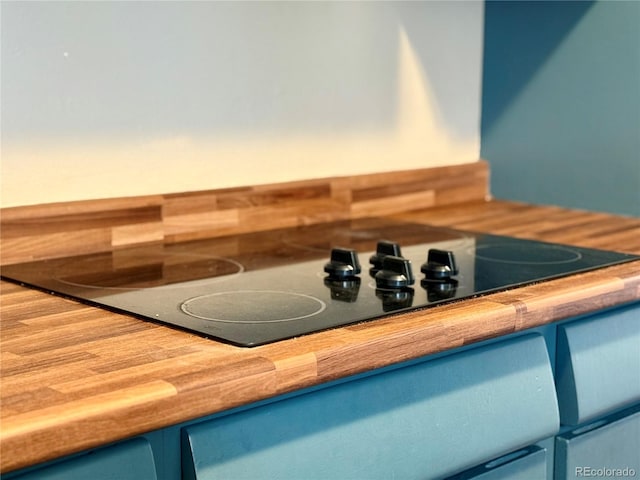 interior details with blue cabinetry and black electric cooktop