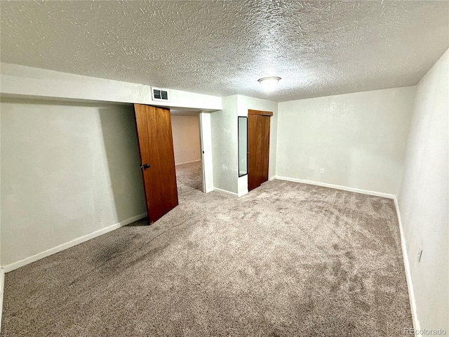 basement featuring a textured ceiling and carpet floors