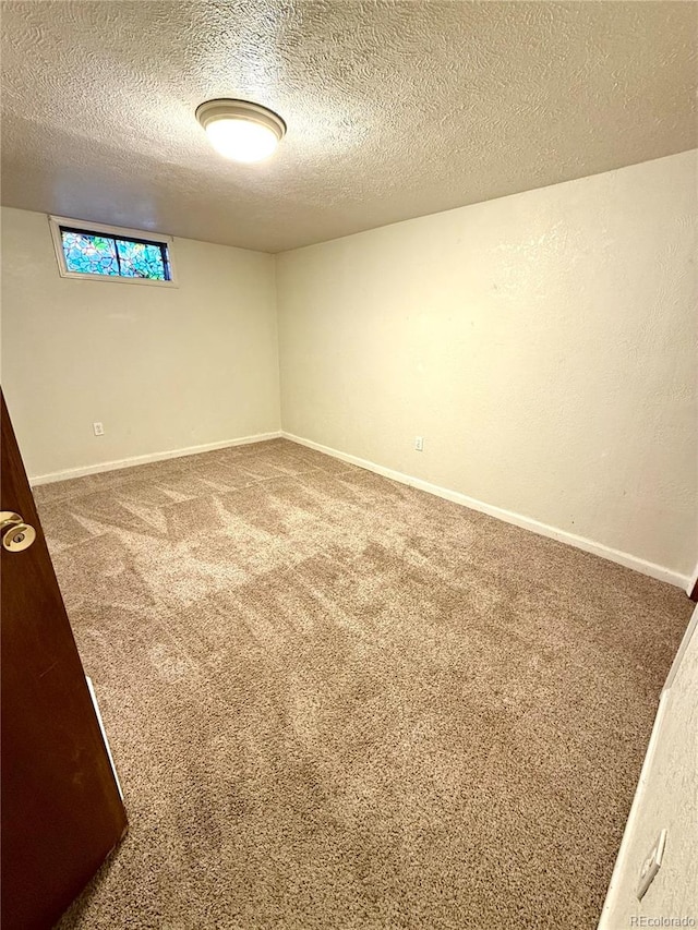 basement featuring a textured ceiling and carpet floors