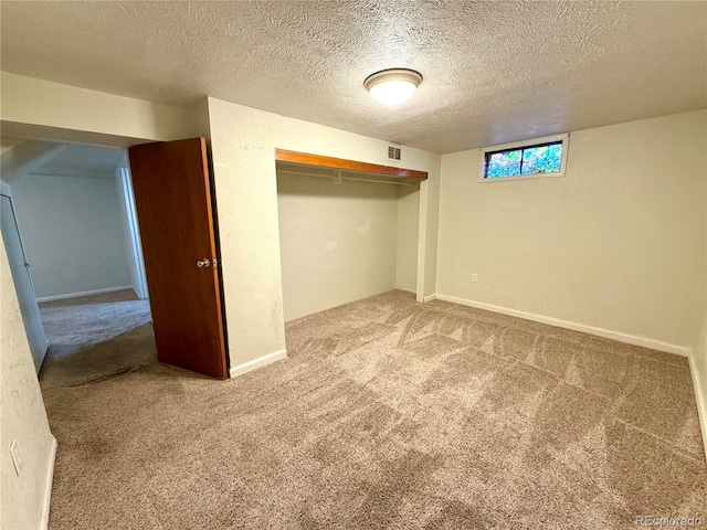 unfurnished bedroom with carpet floors, a textured ceiling, and a closet