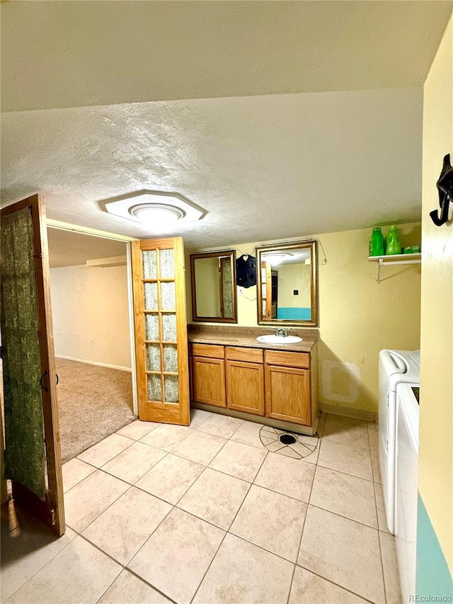 bathroom with vanity, washing machine and clothes dryer, tile patterned flooring, and a textured ceiling