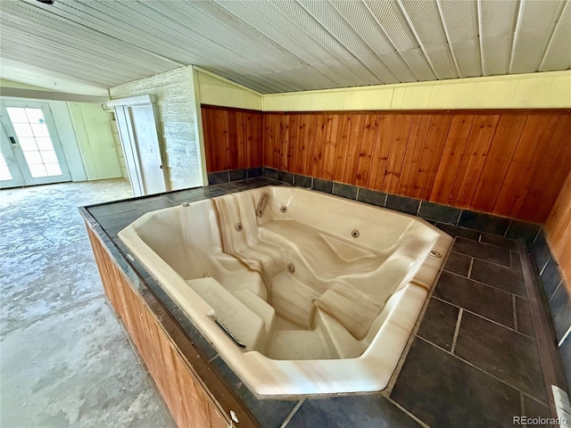 interior space featuring a hot tub and wood walls