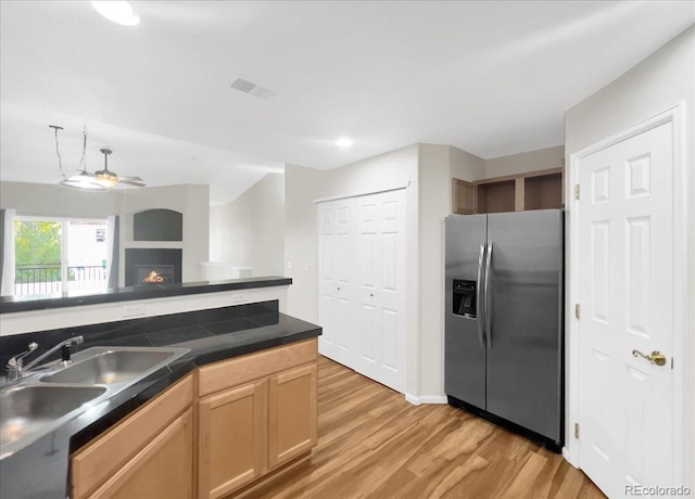 kitchen with a ceiling fan, a sink, stainless steel fridge with ice dispenser, light wood-type flooring, and visible vents
