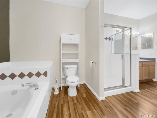 full bathroom featuring a garden tub, a stall shower, wood finished floors, and vanity