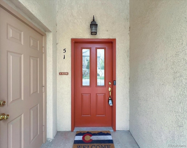 property entrance with stucco siding