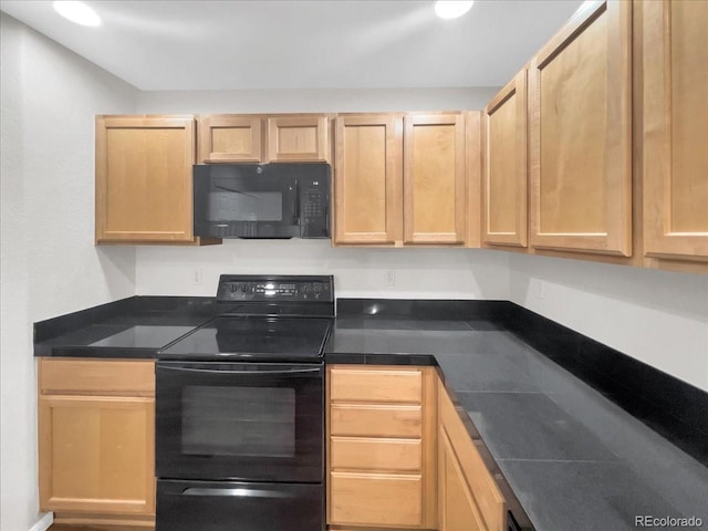 kitchen with dark countertops, black appliances, and light brown cabinetry