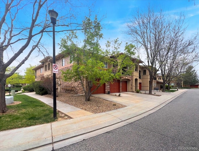 view of front of property with concrete driveway, stone siding, and an attached garage