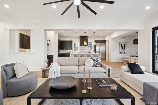 living room featuring ceiling fan and light hardwood / wood-style floors