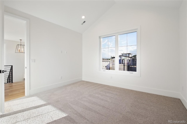 carpeted spare room featuring lofted ceiling