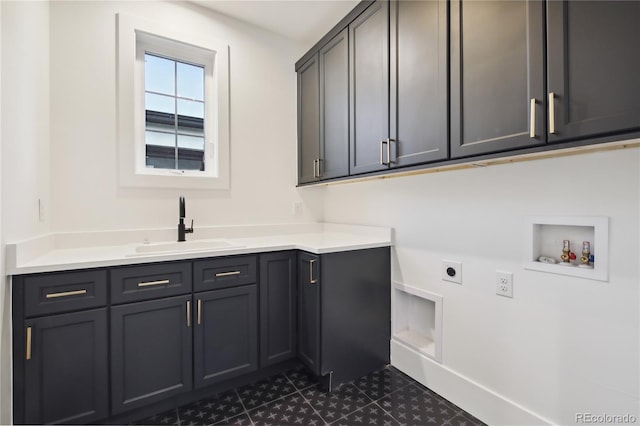 laundry area with hookup for an electric dryer, hookup for a washing machine, cabinets, and sink