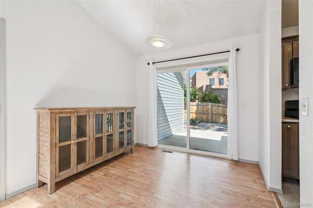 1826 Palm Dr, Colorado Springs, CO 80918 - unfurnished dining area with light wood-style flooring and vaulted ceiling
