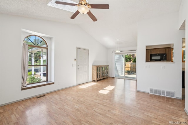 1826 Palm Dr, Colorado Springs, CO 80918 - unfurnished living room with light wood-style floors, healthy amount of natural light, ceiling fan, and vaulted ceiling