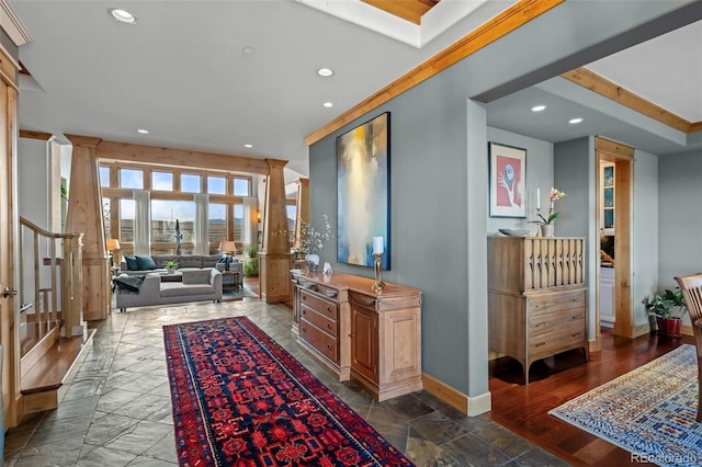 hallway featuring baseboards, recessed lighting, and stairs