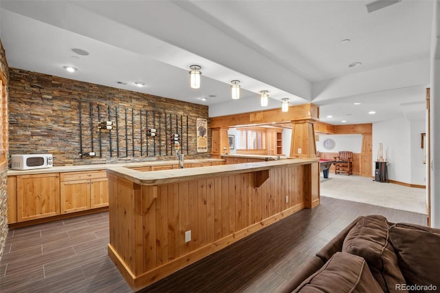 bar with dark wood-style flooring, wet bar, baseboards, white microwave, and recessed lighting