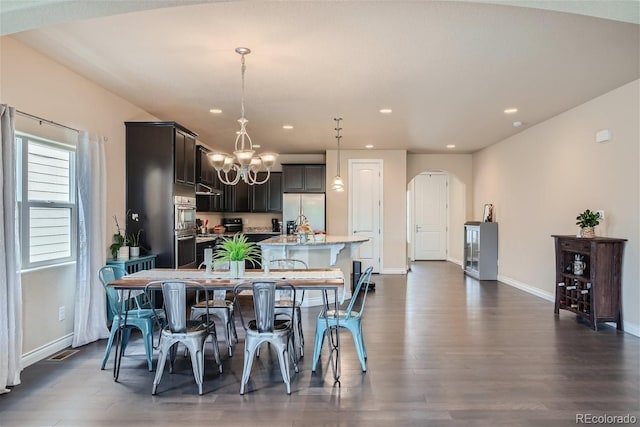 dining room with dark wood-type flooring and an inviting chandelier