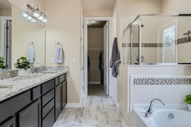 bathroom with separate shower and tub and dual bowl vanity